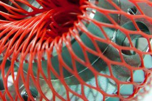 Metallteil mit rotem Kunststoffnetz