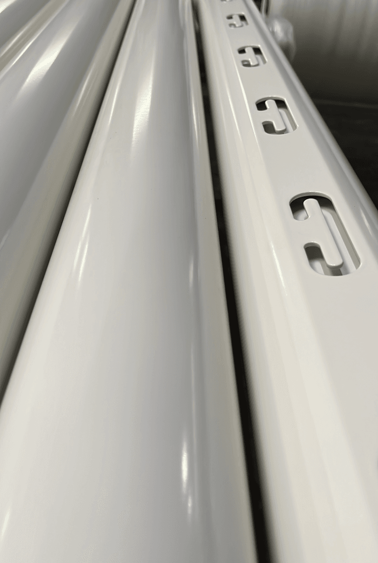 Weiße Metallschienen mit Langlöchern in Nahaufnahme